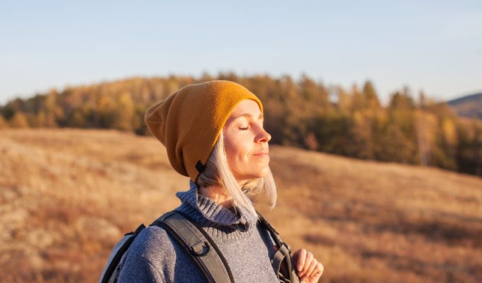 wellness travel: woman hiking in fall